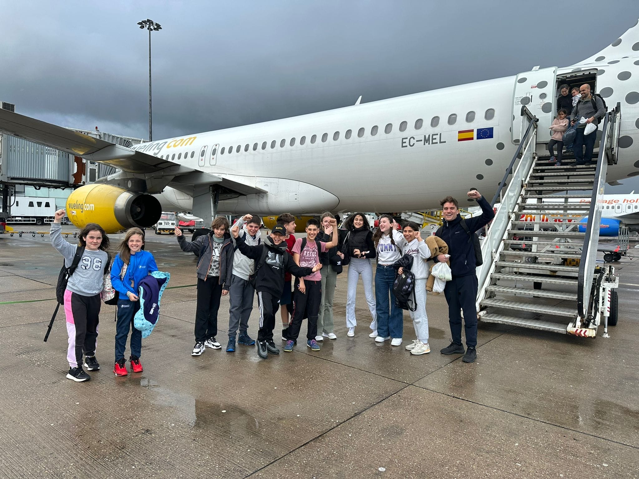 niños en aeropuerto al lado de un avión. Viaje a campamento